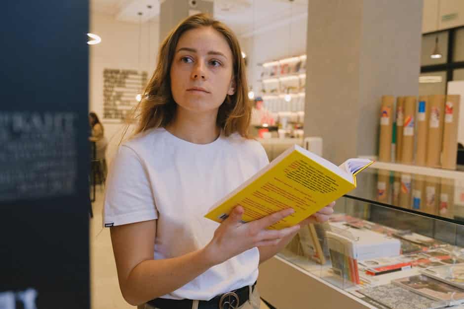 pexels-photo-7561694-7561694 A young woman intently reading a yellow book in a modern library setting.